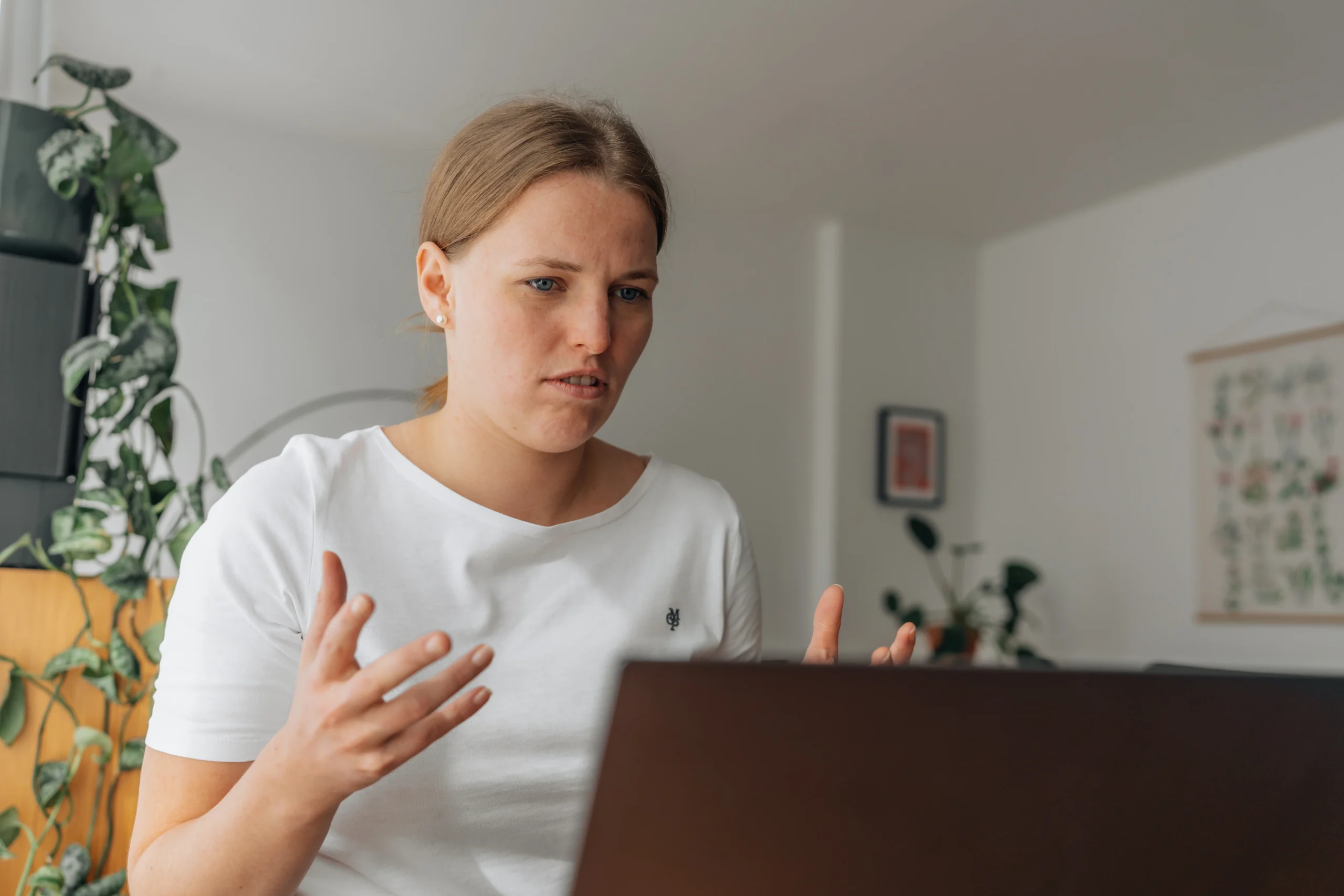 Frau sitzt angespannt und gestikulierend vor ihrem Laptop