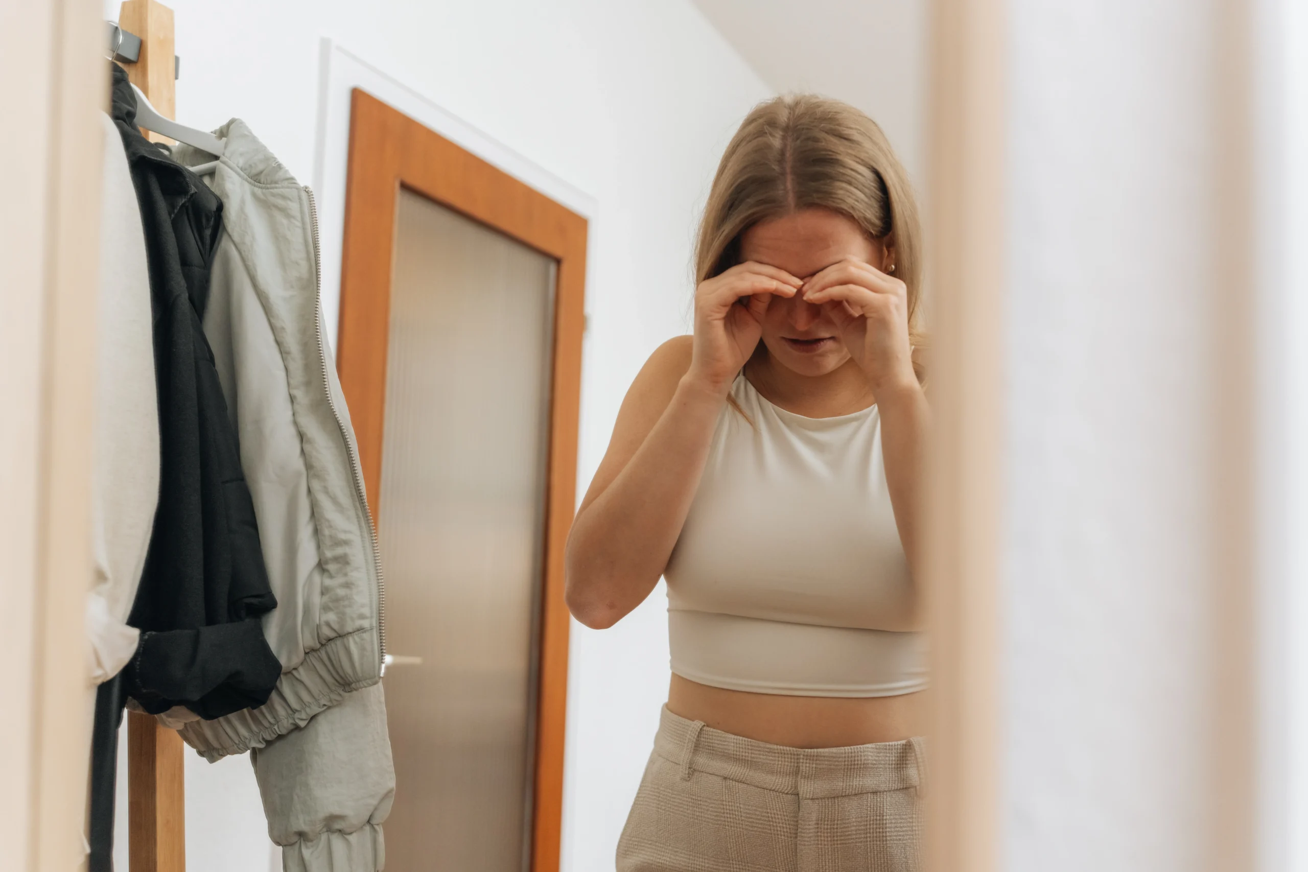 Frau reibt sich mit beiden Händen die Augen.