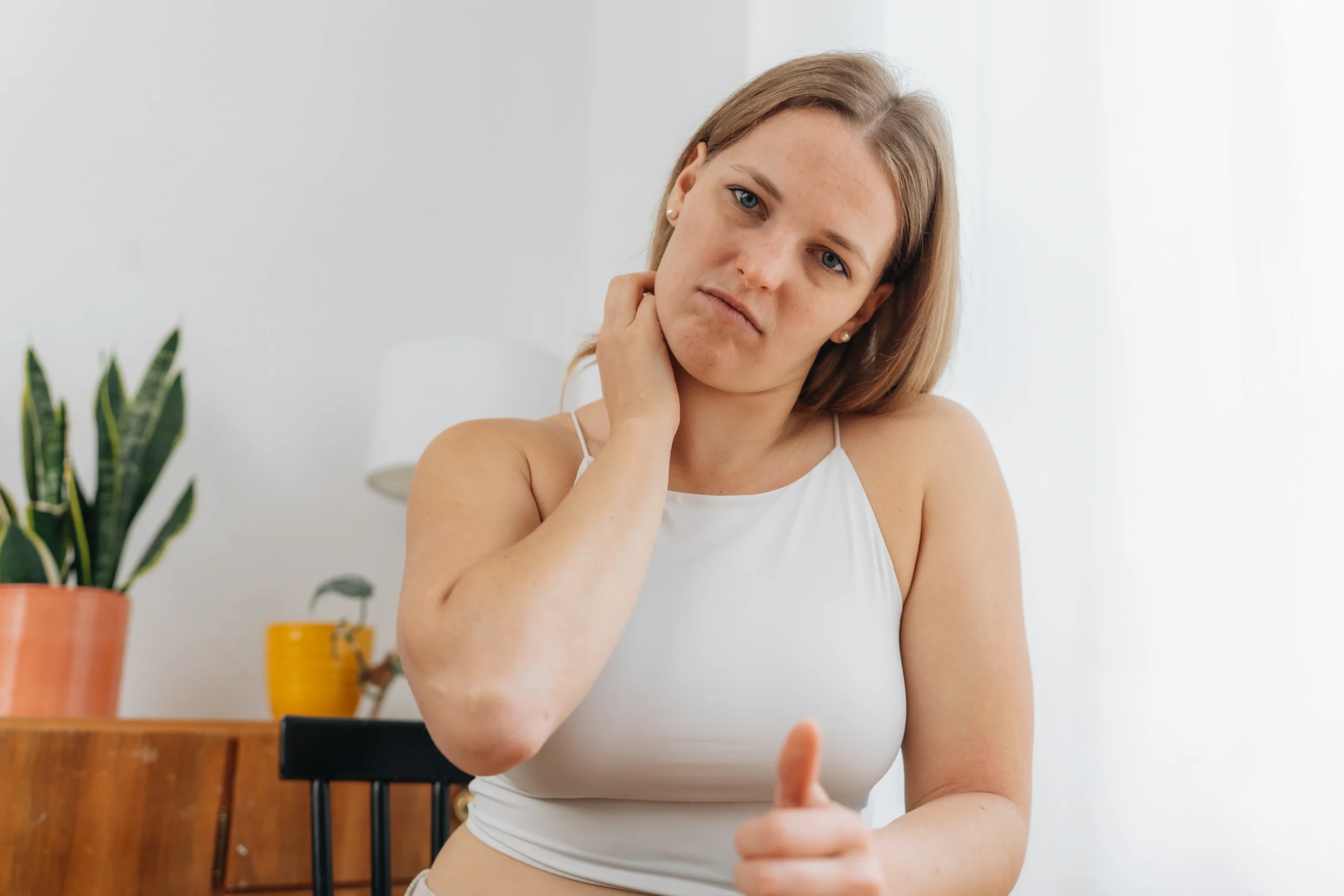 Junge Frau kratzt sich am Hals